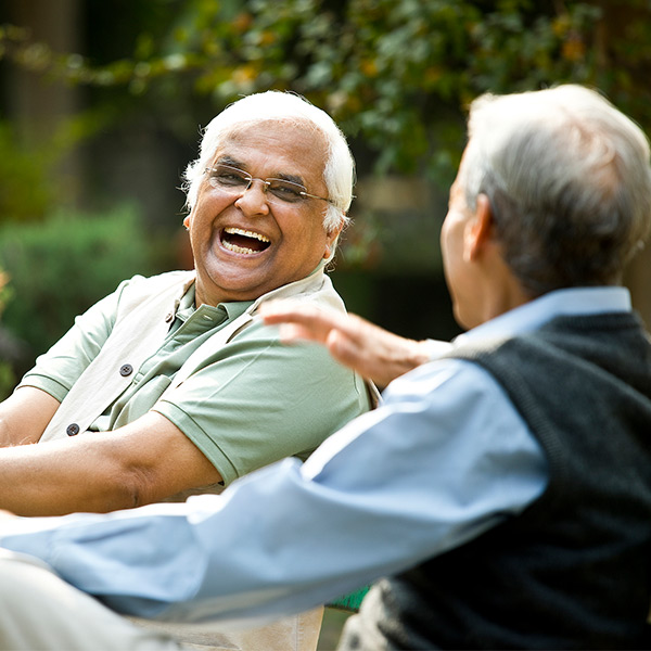 two senior men talking in the yard
